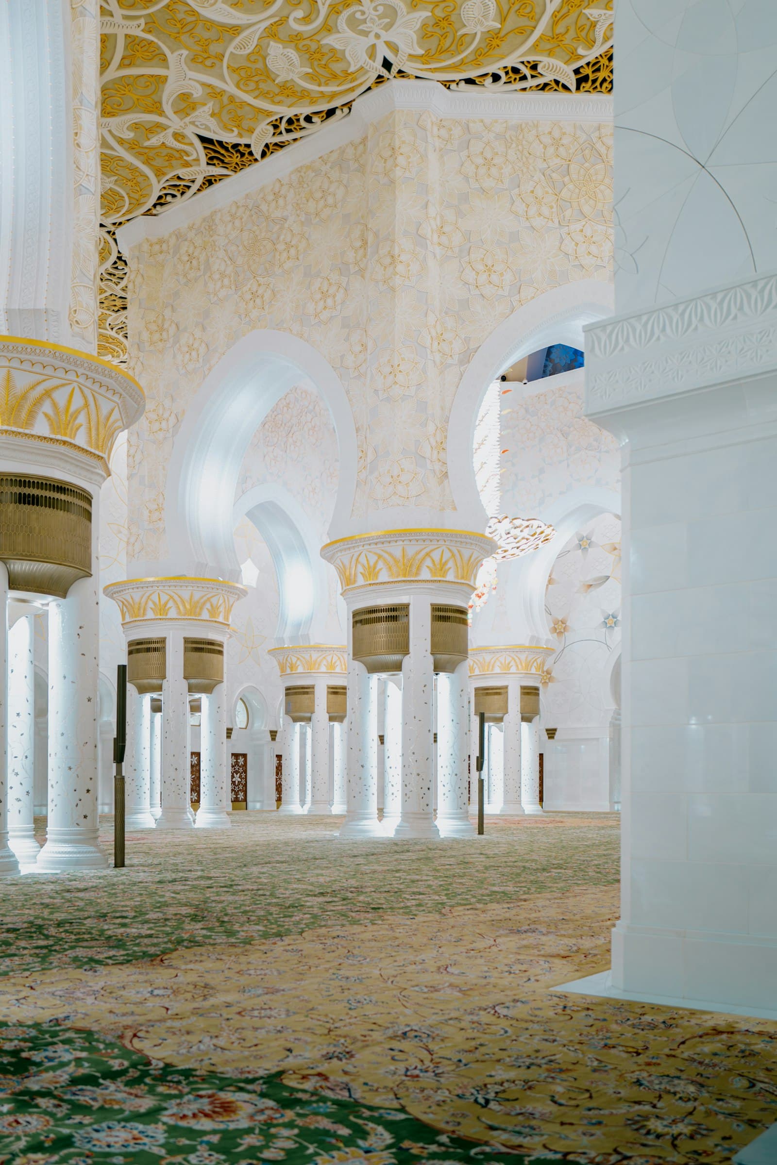 Sunlit arches and gold detail inside a mosque